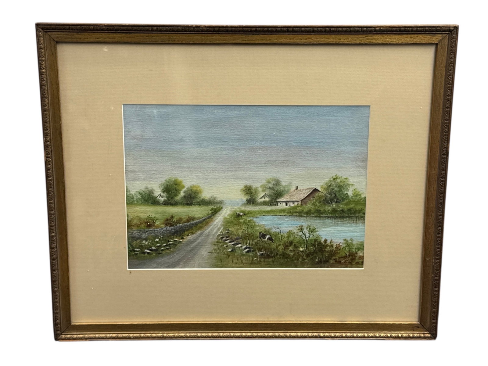 Antique Pastoral Landscape Pastel with Cottage and River, Framed: This antique landscape print depicts a peaceful countryside scene featuring a winding dirt path leading toward a small cottage set beside a calm river. Lush greenery, trees, and a soft sky create a