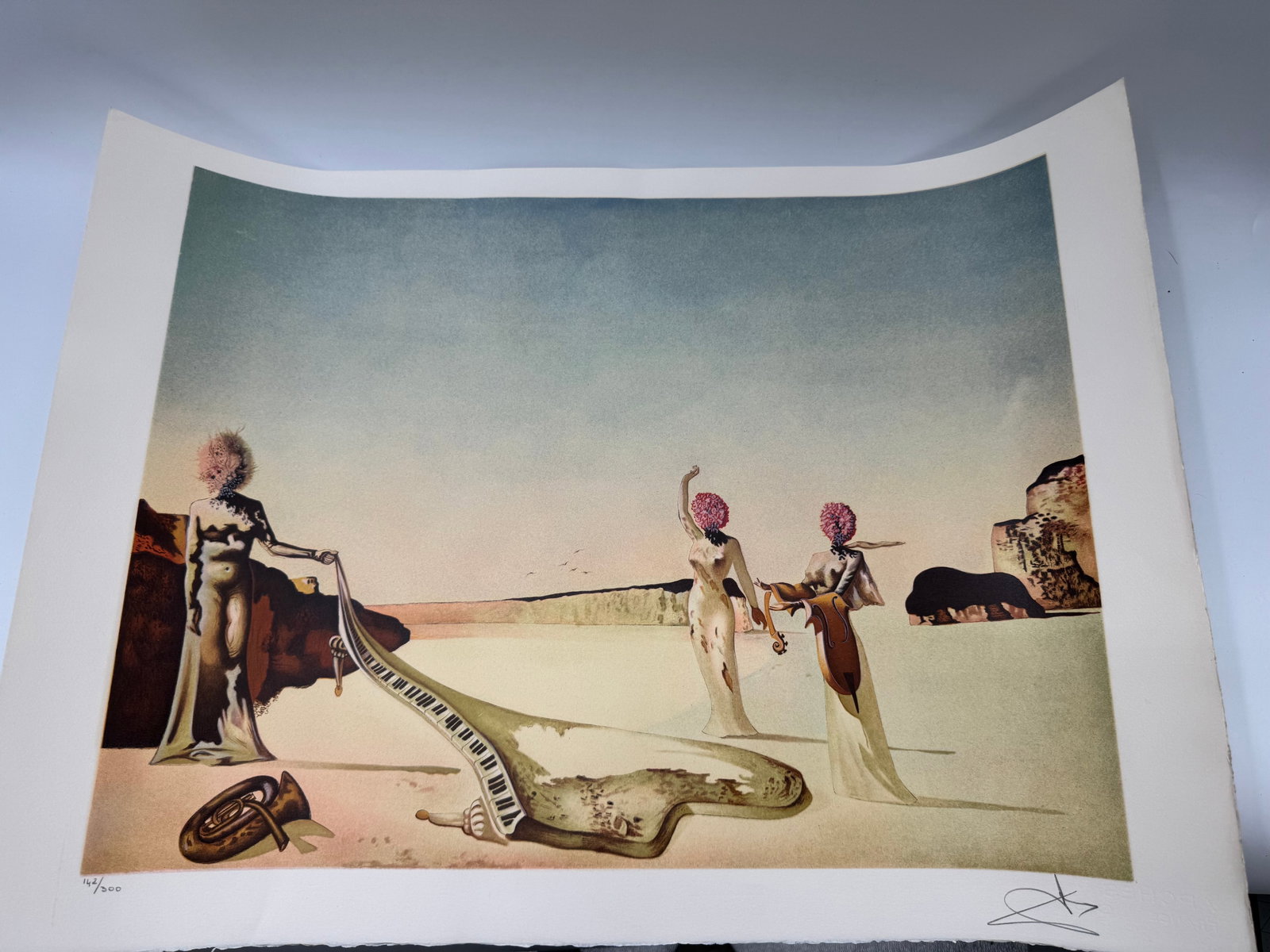 Salvador Dali Lithograph - Surrealist Figures with Tuba, Signed & Numbered: Salvador Dali lithograph on paper, featuring surrealist figures and a tuba in a dreamscape setting. Signed in the lower right and numbered 142/300 in the lower left. Dimensions: 30 x 21.5 inches.
