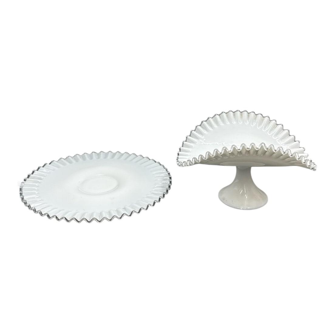 Milk Glass Serving Platter and Pedestal Compote with Ruffled Edge: This two-piece milk glass serving set includes a large round platter and a matching pedestal compote, each featuring an elegant ruffled edge with a scalloped, sawtooth-style rim. The opaque white