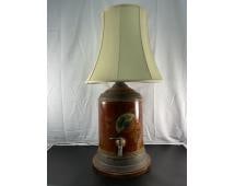 Antique Toleware Tea Canister Lamp: A vintage or antique toleware tea canister repurposed into a table lamp. The lamp features a cylindrical metal body with hand-painted decorative gold accents over a deep red base. It retains its origi