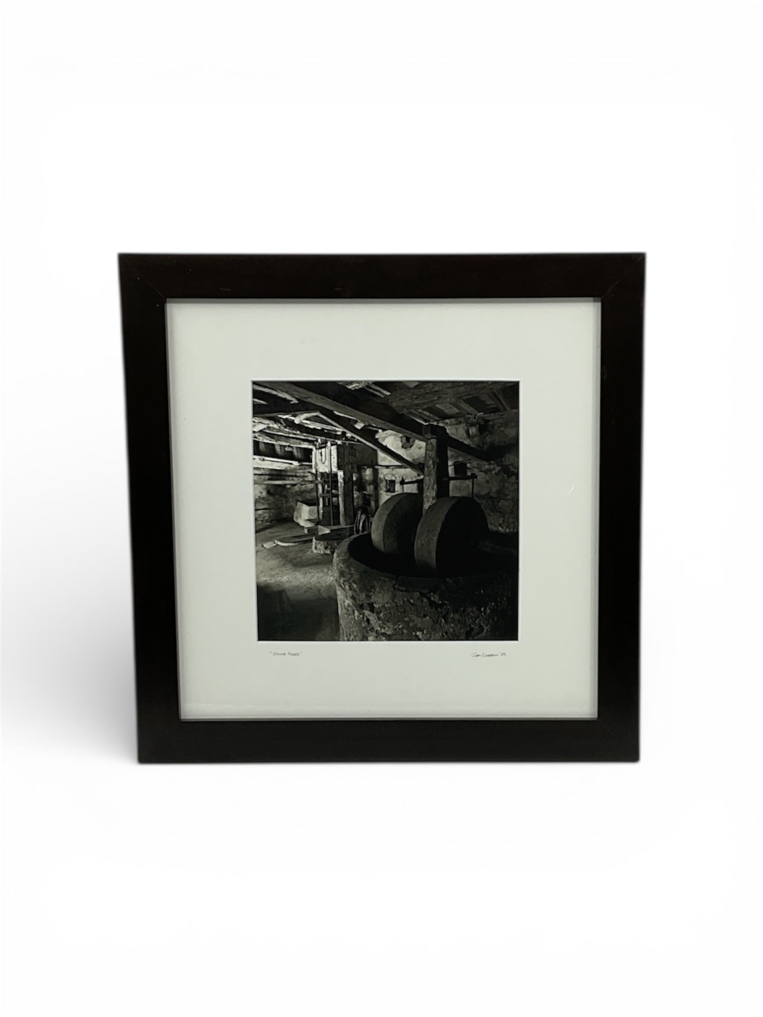 Sam Dobrow Olive Press Figurative Artwork 2009: Figurative artwork by Sam Dobrow titled Olive Press, dated 2009. The composition depicts an interior view of a traditional olive press, focusing on the massive stone wheels and heavy wooden beams that