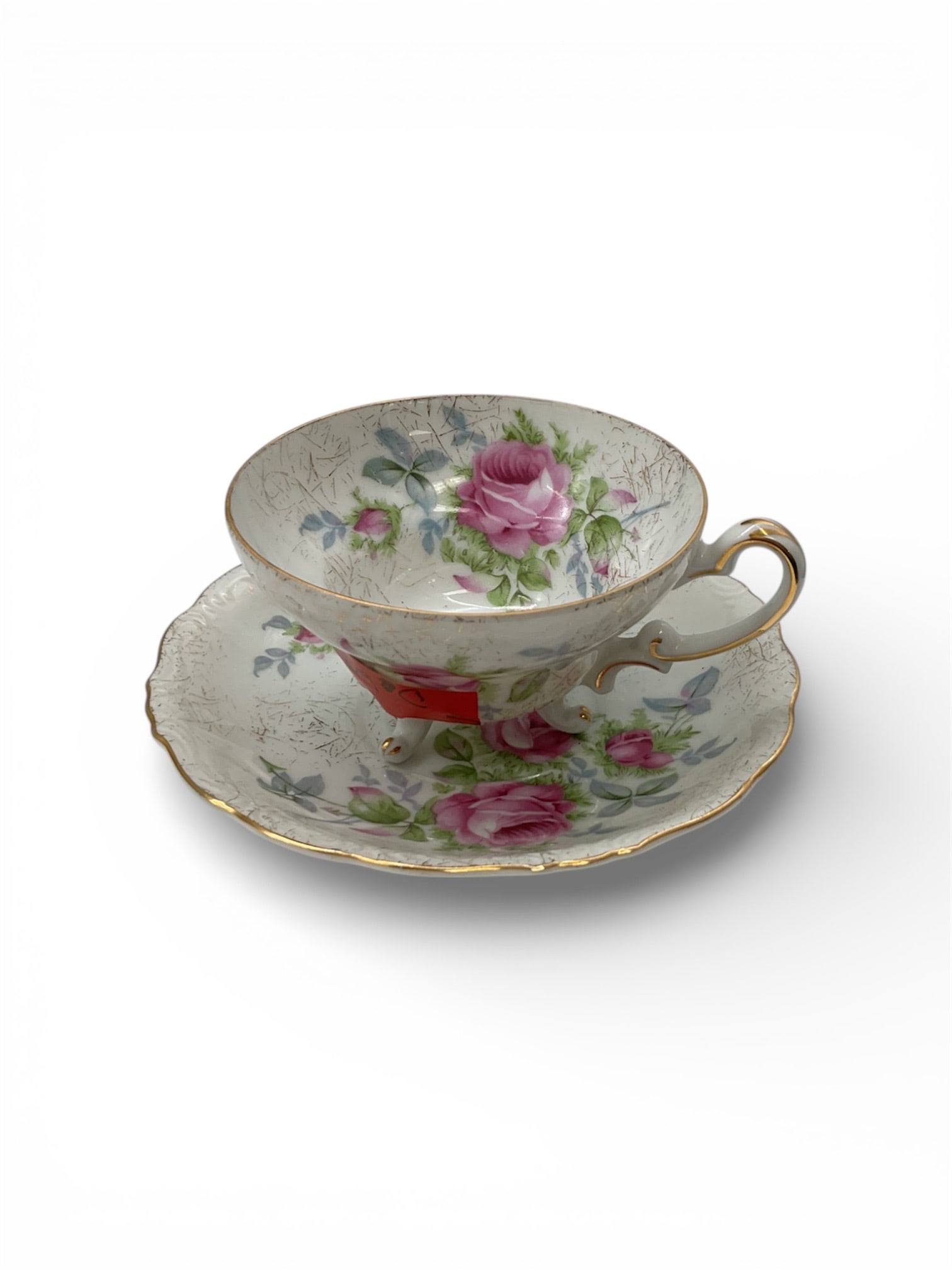 Dresden Rose Porcelain Demitasse Cup and Saucer with Gilt Trim: This porcelain demitasse cup and saucer set features the classic Dresden Rose pattern, showcasing finely detailed pink roses with green foliage against an ivory ground. The decoration is enhanced by