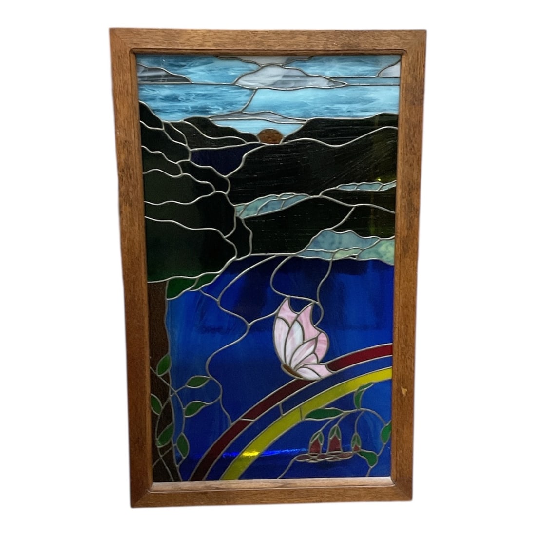 Stained Glass Landscape Panel with Lotus and Hills: This decorative stained glass panel features a serene landscape composition with rolling dark hills beneath a softly lit sky, transitioning into vivid blue waters in the foreground. A stylized lotus