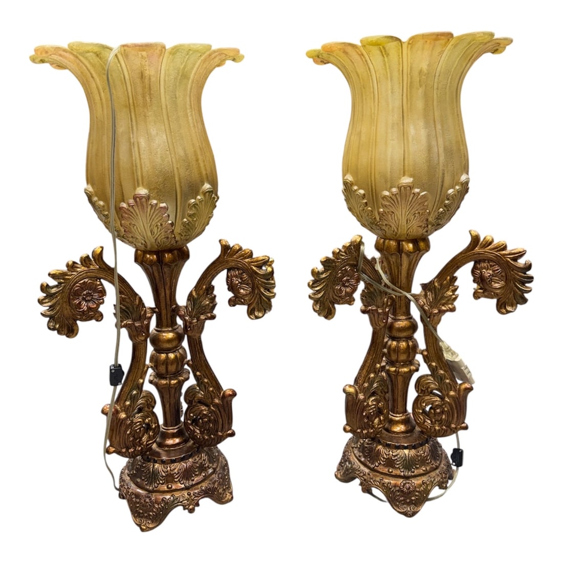 Pair of Italian Style Gilt Metal and Glass Floor Lamps: An impressive pair of Italian style floor lamps featuring large fluted glass shades rising from ornate gilt metal bases. Each lamp is richly decorated with elaborate scrolling acanthus leaf arms, flor