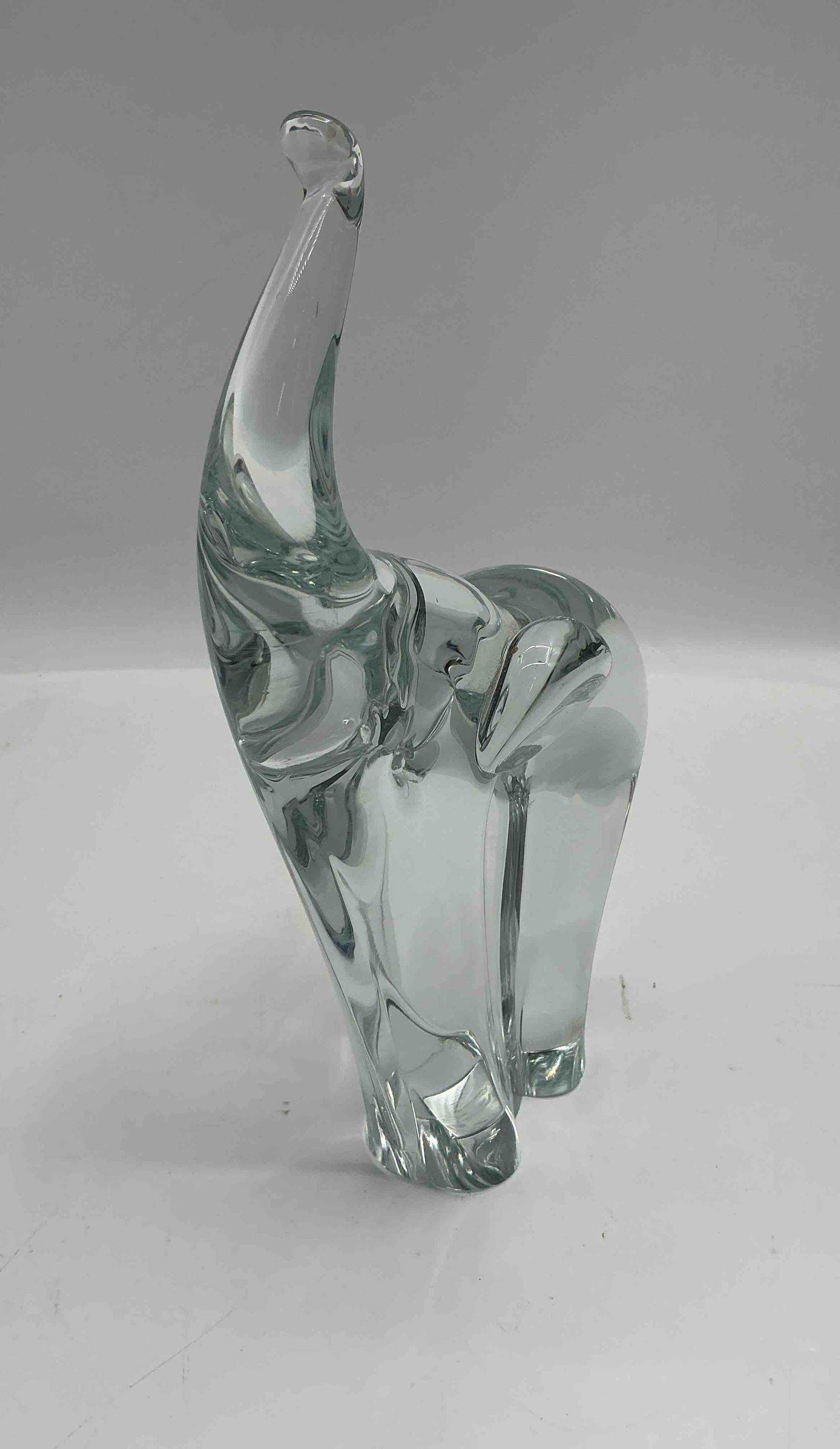 Murano Clear Glass Elephant Sculpture: Elegant Murano glass elephant sculpture crafted in clear glass with a stylized form and raised trunk. Hand-blown in Italy, showcasing the quality and smooth finish typical of Murano glass artistry.