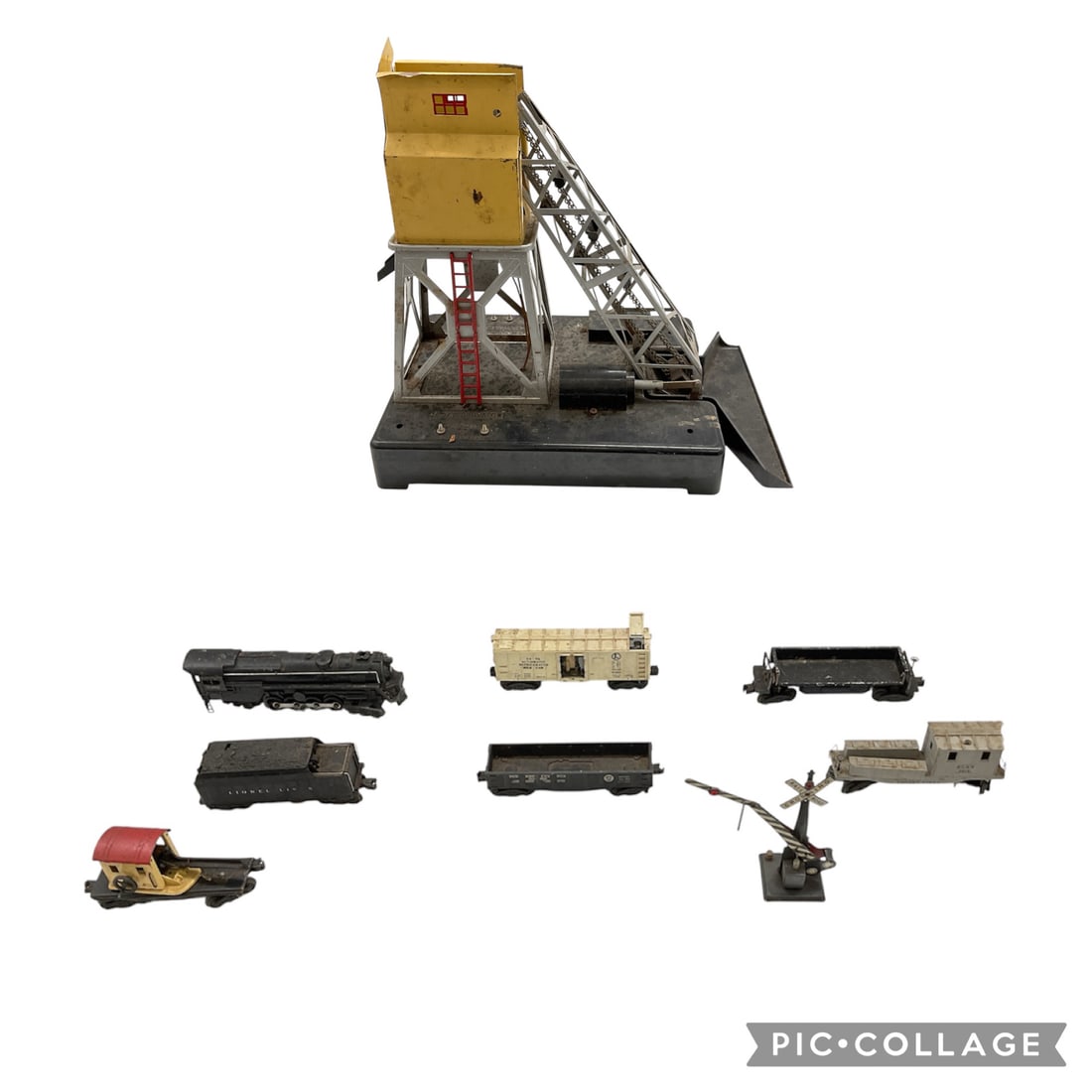 Vintage Model Train Crane and Rail Car Collection: Collection of vintage model train components including a large operating crane structure, multiple freight and passenger cars, and trackside accessories. The crane features a metal framework with