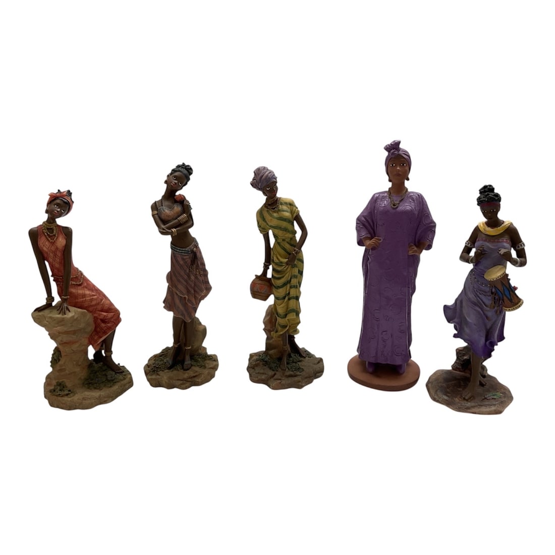 Collection of Five African Inspired Female Figurines: Decorative collection of five African inspired female figurines, each depicting women in traditional dress and expressive poses. The figures are finely detailed with textured garments, headwraps, and