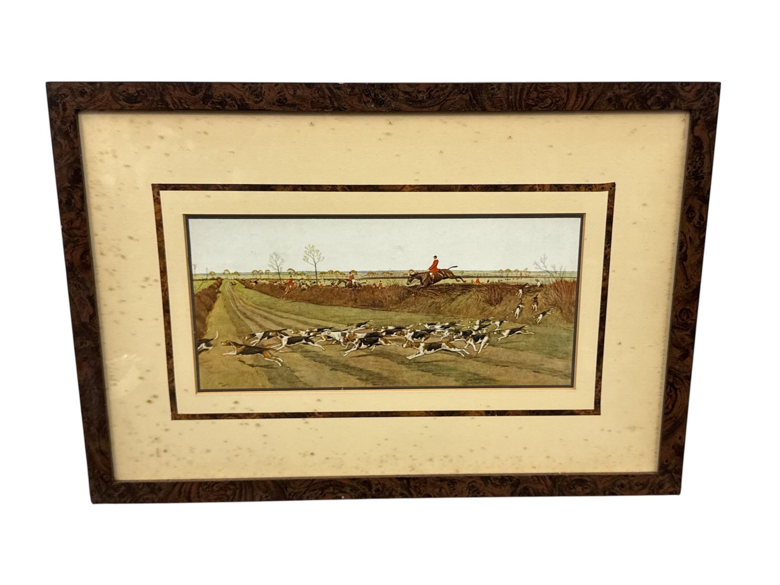 Oliver Alvin Lux English Hunt Scene Framed Print: Framed print depicting a traditional English hunt scene with riders on horseback and a pack of hounds moving across open countryside. The composition captures the pastoral landscape and sporting tradi