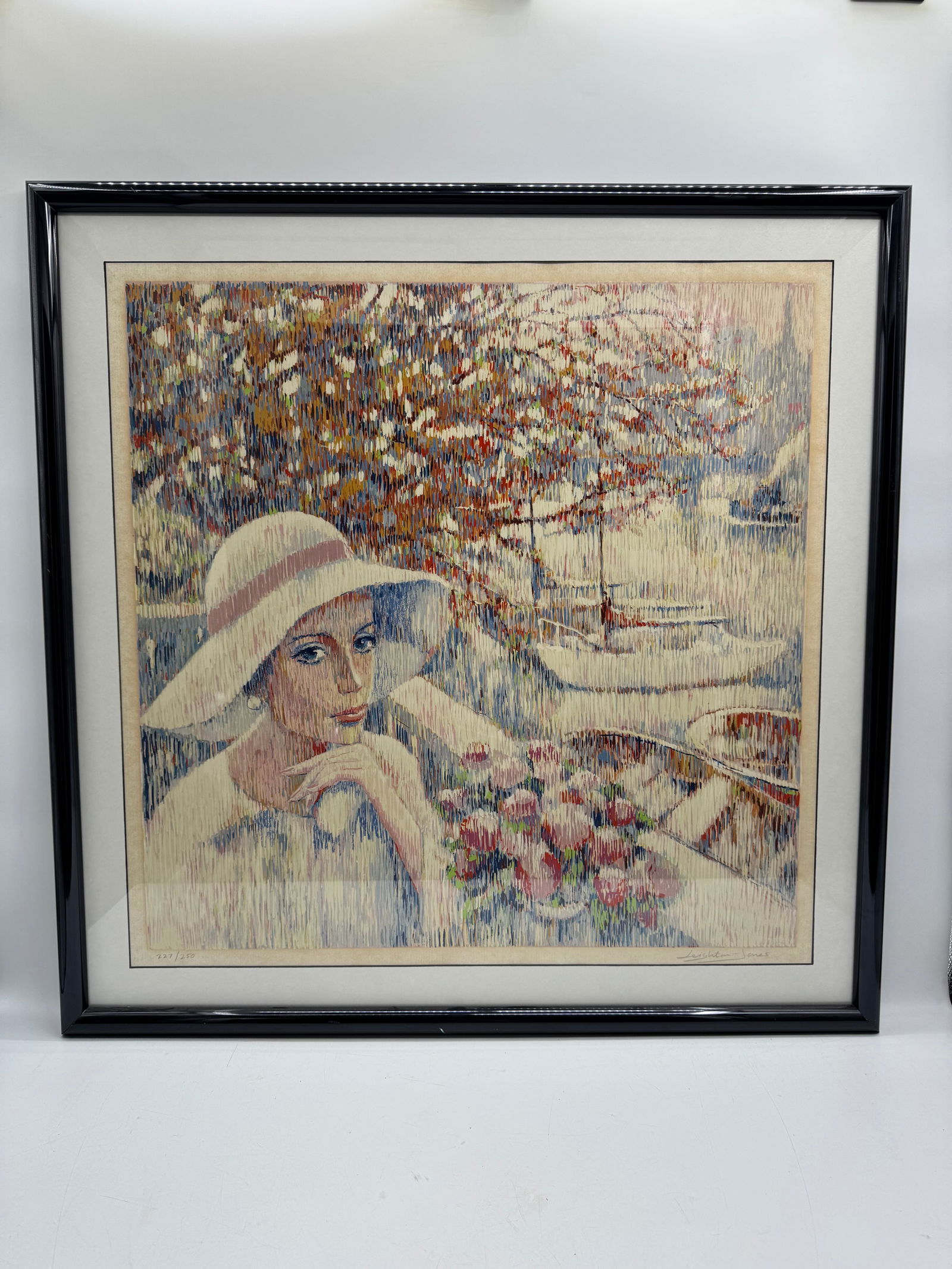 Leighton Jones, Woman with Flowers, Print 227/250: Leighton Jones, limited edition print, numbered 227/250. Depicts a woman with flowers in a hat, with a sailboat in the background. Framed and glazed. Dimensions: 38 x 38 inches.
