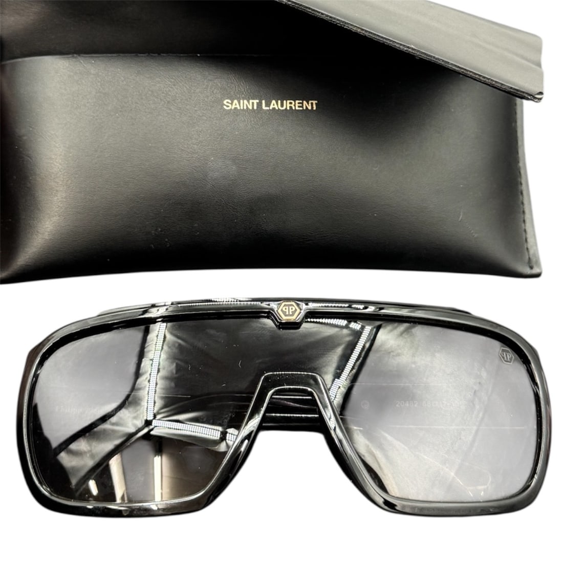 Philipp Plein Shield Style Sunglasses Made in Italy with Saint Laurent Case: A bold pair of Philipp Plein shield style sunglasses featuring a dramatic oversized wraparound lens design and sculptural black frame. The upper frame is accented with metallic Philipp Plein branding