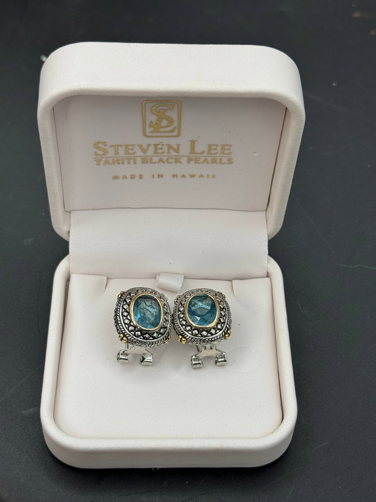 Stephen Lee Salmon Pearls Blue Stone Clip Earrings: A striking pair of designer earrings by Stephen Lee of Salmon Pearls, presented in the original branded presentation box marked Made in Israel. The earrings feature oval blue stones set within ornate