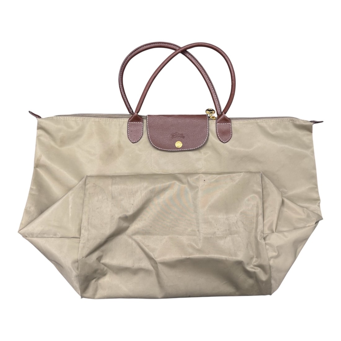 Longchamp Le Pliage Large Foldable Tote Bag: A classic Longchamp Le Pliage large tote bag featuring the brand’s signature foldable design in durable beige nylon with brown leather trim. The bag is accented with double leather top handles a