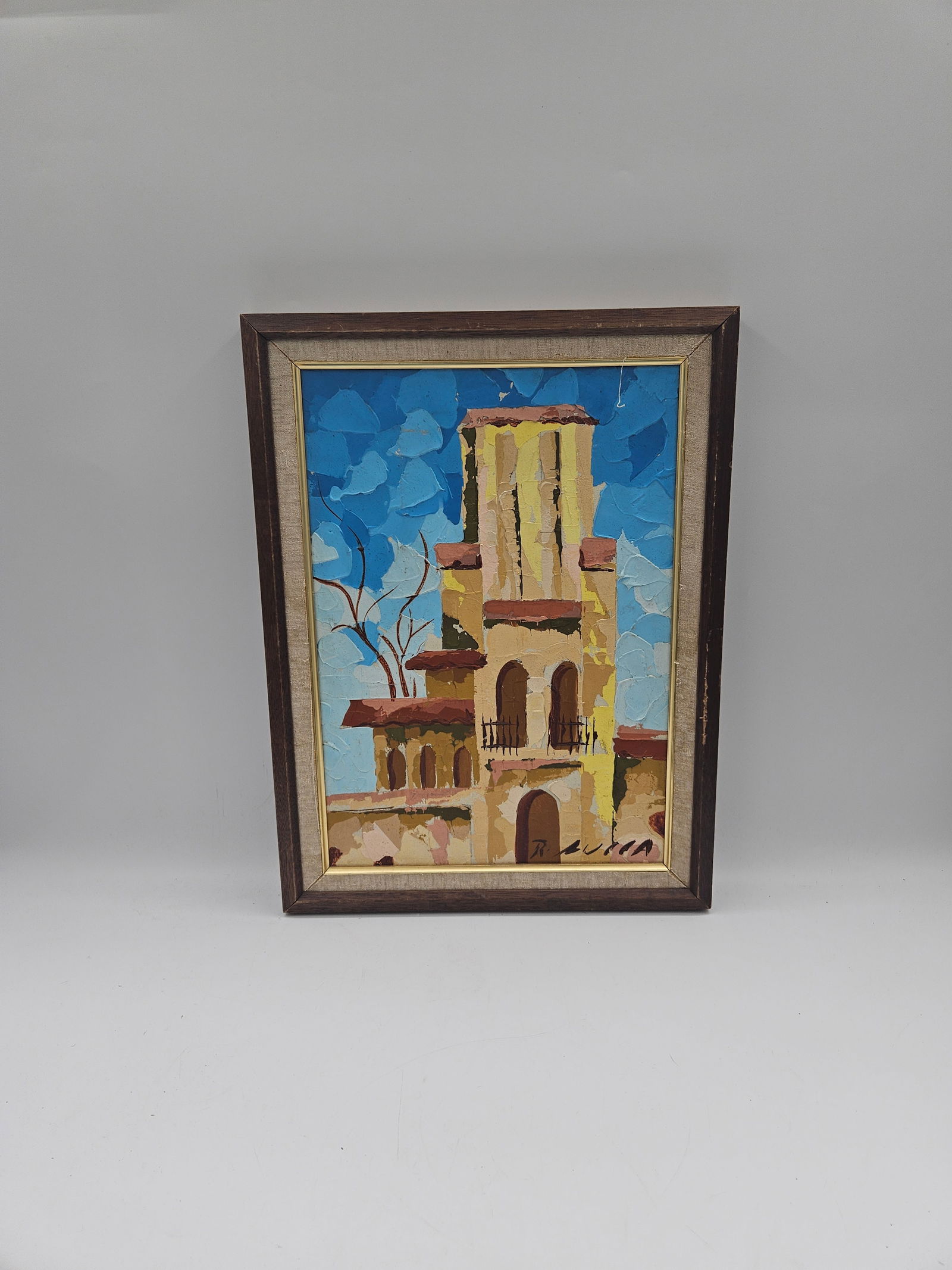Mid-Century Architectural Abstract Painting: A textured modernist painting depicting a sunlit Mediterranean-style building beneath a bright blue sky. The artist’s signature appears in the lower right corner but is unclear. The piece