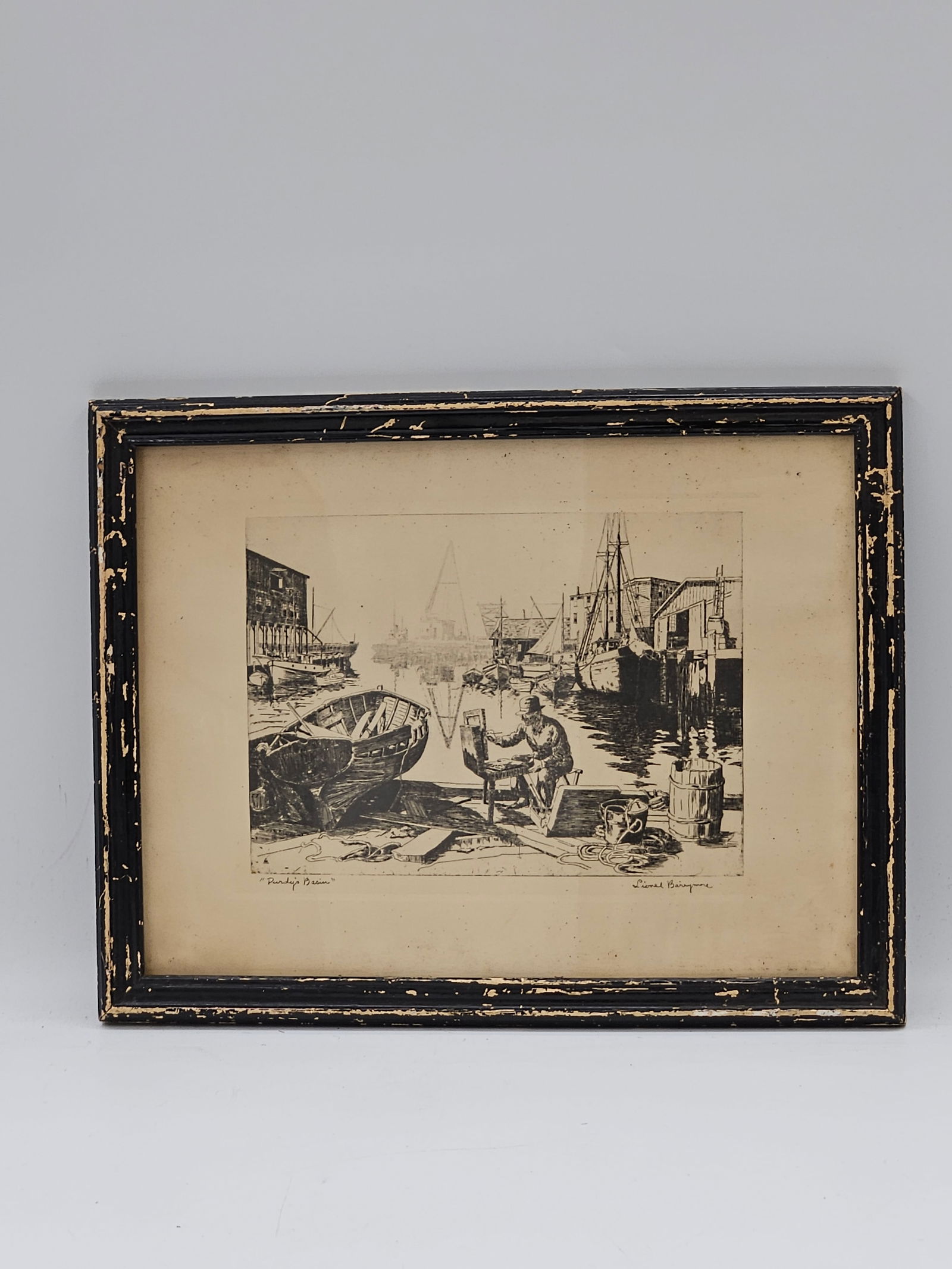 Purdy’s Basin by Lionel Barrymore: A black-and-white etching titled Purdy’s Basin by renowned actor and artist Lionel Barrymore. The work depicts a bustling harbor scene with boats and fishermen along the