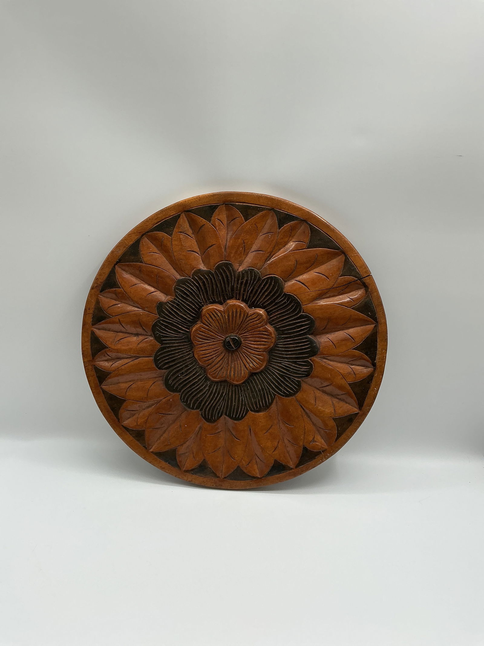 Supersized rare double sided hand carved table centerpiece:  hand-carved wooden wall plaque. features a floral design on one side another a fish with floral accents on the other. Each side exhibits unique carving details and a warm wood tone.