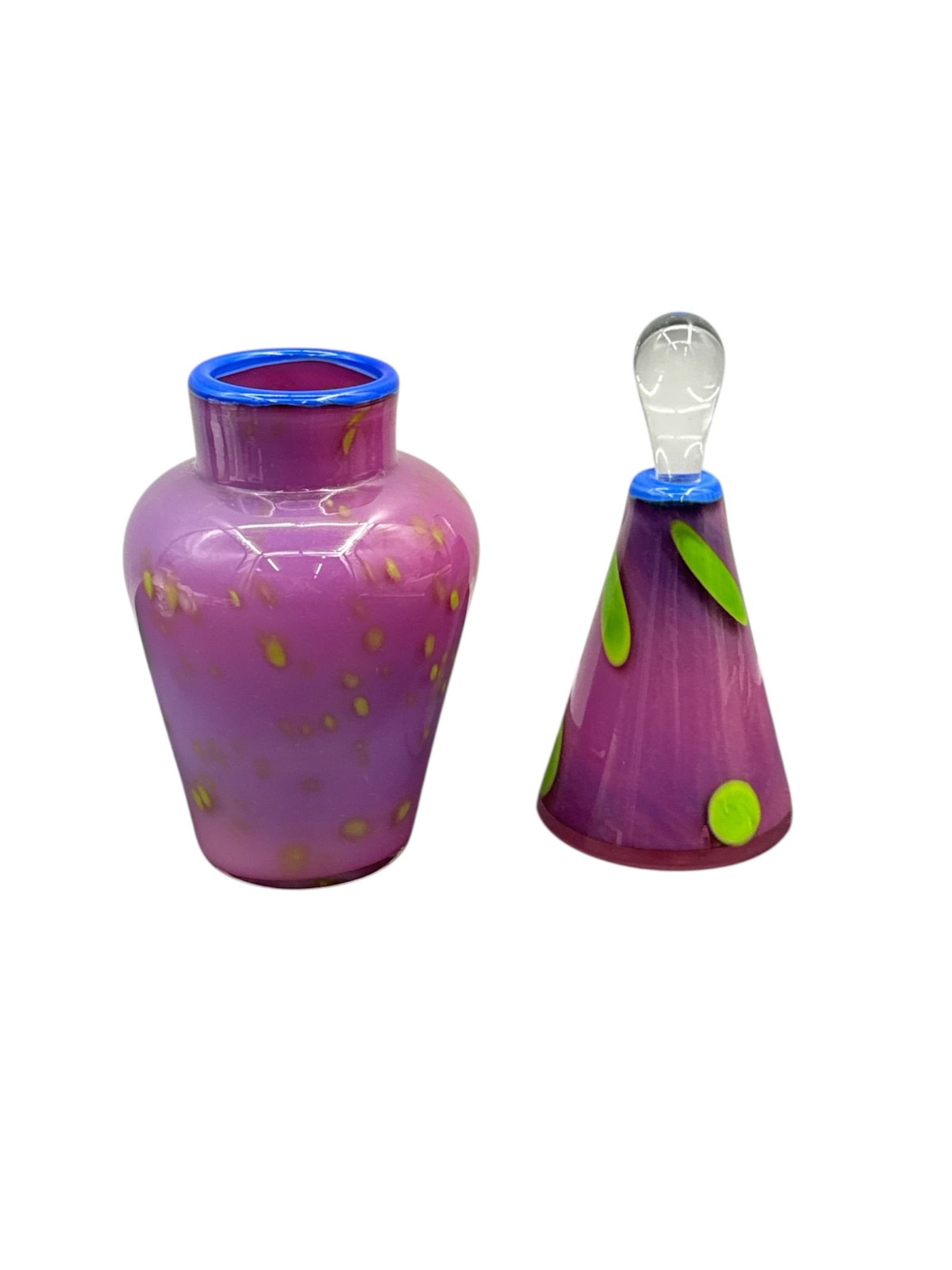 Signed Italian Art Glass Vase and Bottle with Stopper Set: This decorative art glass set includes a small vase and a matching bottle with stopper, both rendered in vibrant pink glass with applied decorative accents. The vase features a softly rounded form wit