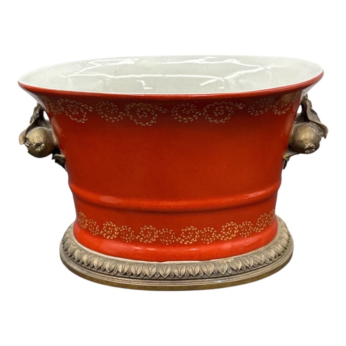 Windward Neoclassical Style Porcelain Cachepot: This elegant, footed cachepot (or planter) features a striking burgundy or coral red glaze accented by delicate gilded floral scrollwork. The piece is designed in