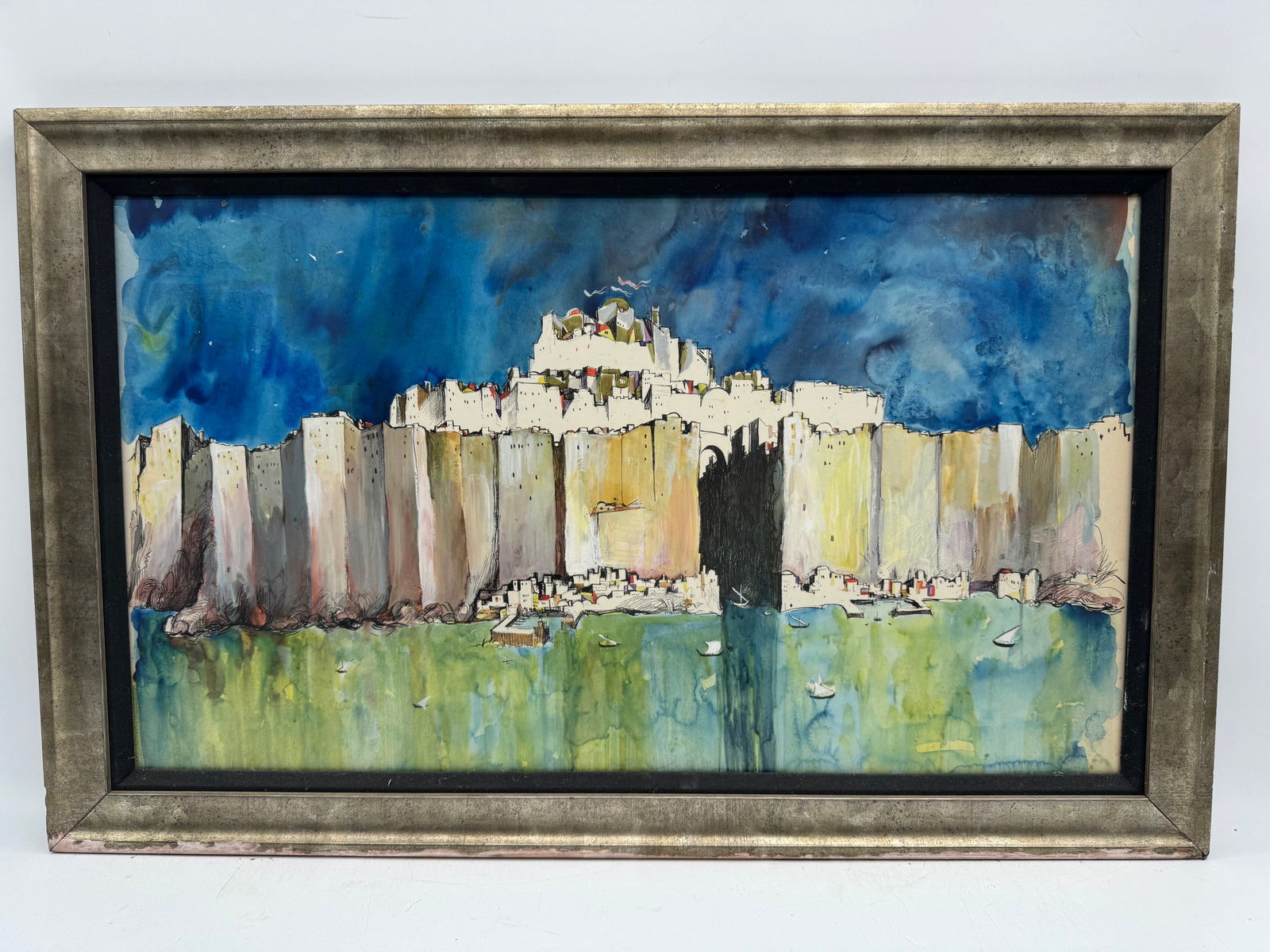 Abstract Cityscape Painting: Abstract cityscape painting featuring a walled city reflected in water under a blue sky. Framed. Dimensions: 34 x 22 inches.