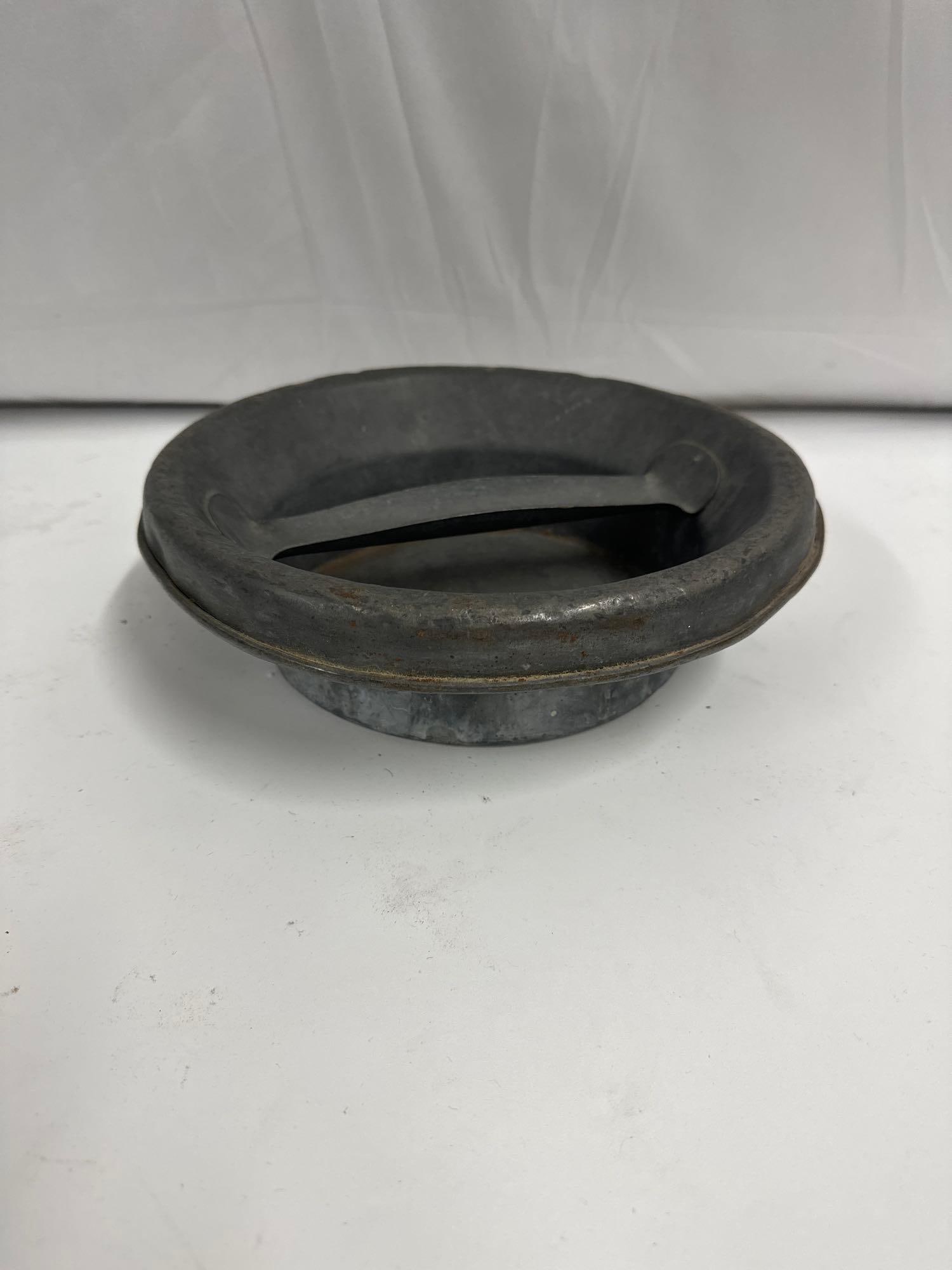 Antique Cast Iron or Galvanized Metal Livestock Feeding or Watering Bowl: This appears to be an antique cast iron or galvanized metal livestock feeding or watering bowl, likely used for farm animals such as horses, cattle, or pigs. The bowl features a raised center bar,