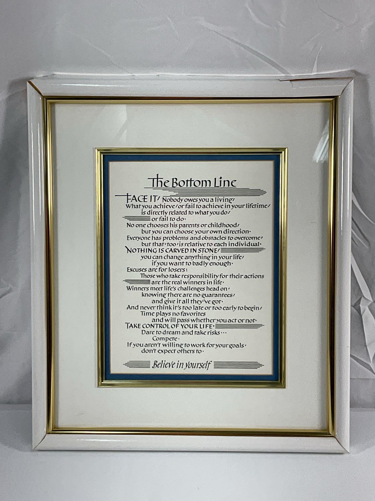Framed inspirational print titled "The Bottom Line,": This is a framed inspirational print titled "The Bottom Line," which features motivational text about personal responsibility, self-belief, and success. The print is professionally matted and enclosed