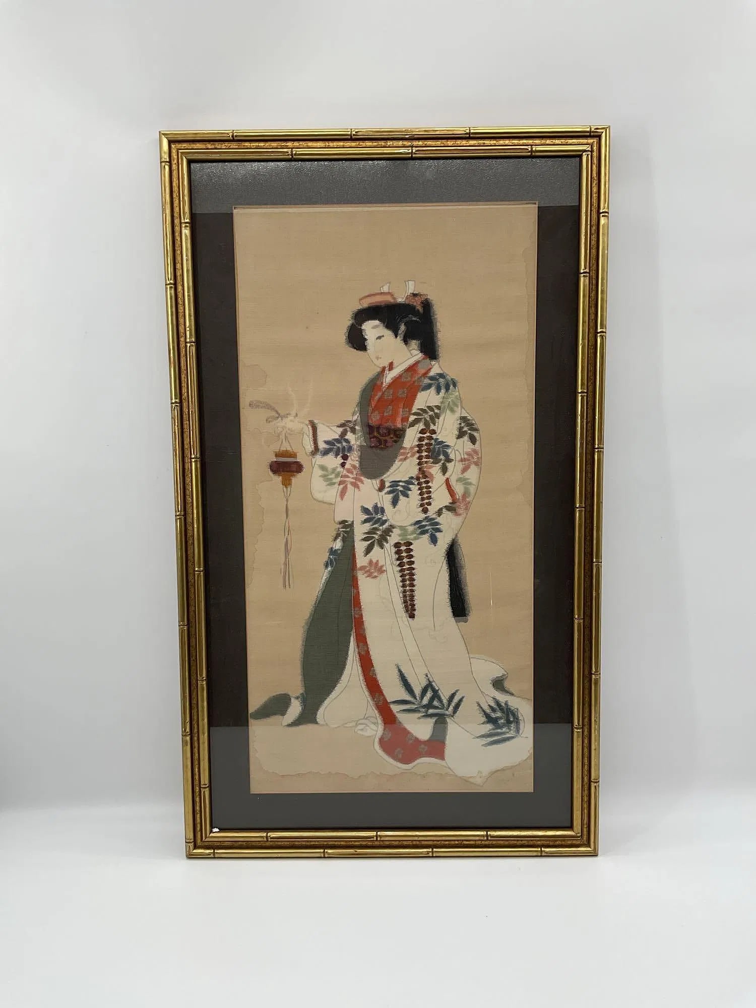 Japanese Geisha with Incense: This framed artwork depicts a traditional Japanese geisha dressed in a flowing kimono adorned with floral and botanical patterns. She is holding an incense burner in one hand, from which delicate smok