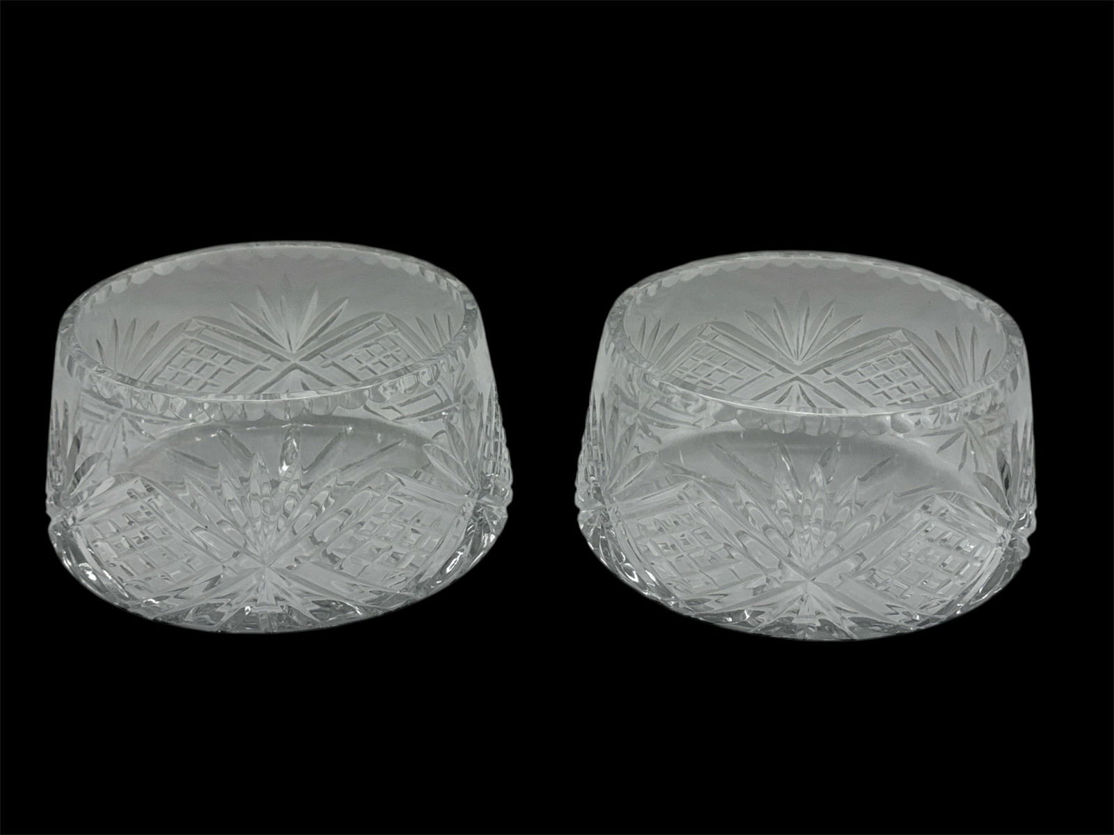 Pair of Cut Crystal Round Serving Bowls with Starburst Pattern: Classic pair of heavy cut crystal round serving bowls featuring deeply faceted starburst and crosshatch patterns throughout. The bold geometric cutting enhances brilliance and light refraction, while