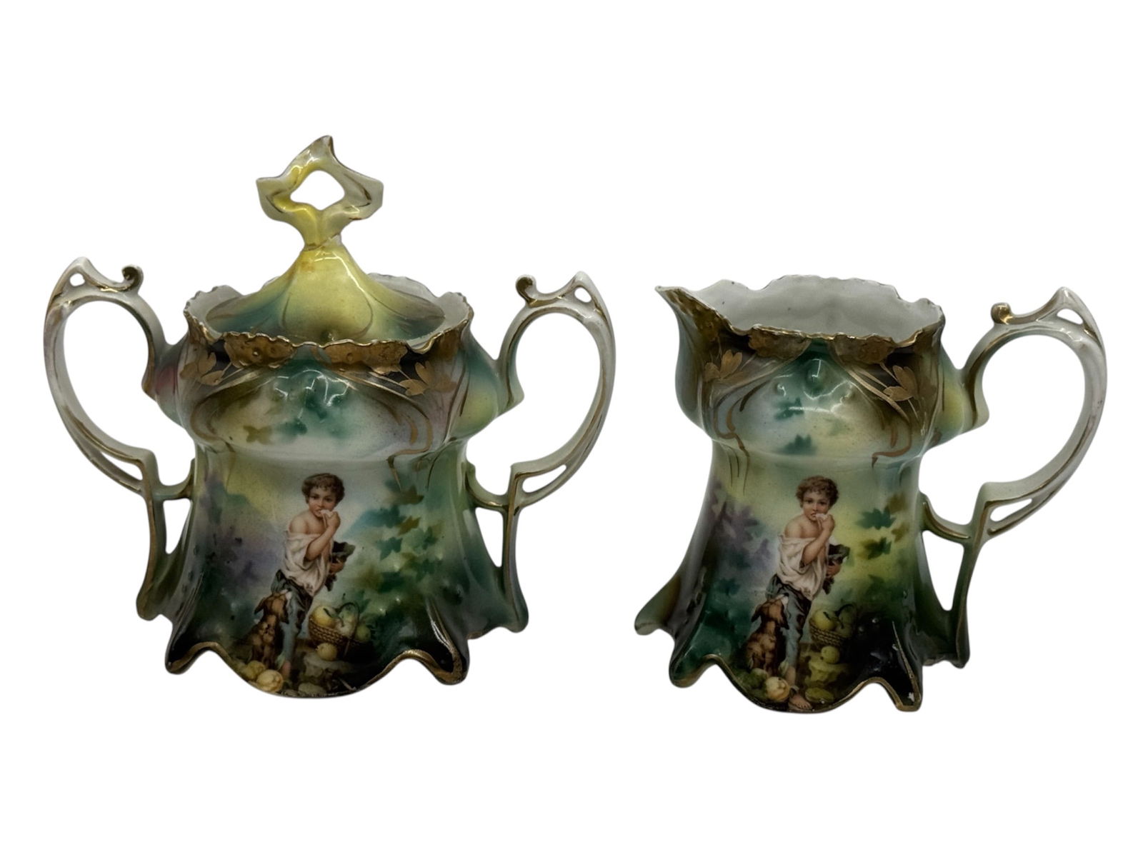 RS Prussia Porcelain Covered Sugar Bowl and Creamer Set: A decorative antique porcelain sugar bowl with lid and matching creamer produced by R.S. Prussia, Germany, late 19th to early 20th century. Each piece features a molded Art Nouveau form with flowing h