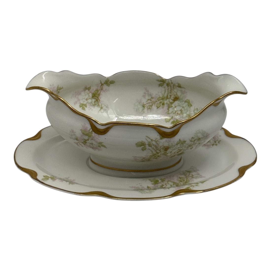 Haviland Limoges Porcelain Gravy Boat with Underplate: A Haviland Limoges porcelain gravy boat with matching underplate featuring an elegant scalloped form with molded edges and gilt trim. The piece is decorated with delicate green floral sprays across th