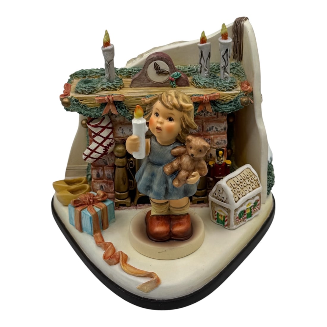 Goebel Hummel Christmas Wish Musical Figurine: A Goebel Hummel musical figurine titled Christmas Wish from the M.I. Hummel Music Box Collection. The scene depicts a young child holding a candle and teddy bear while standing in front of a decorated