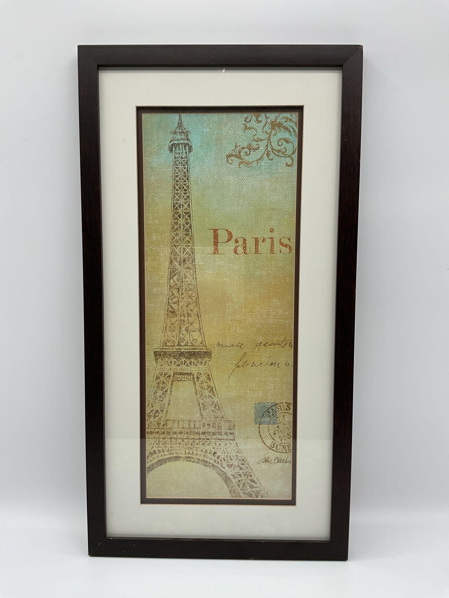 Framed Eiffel Tower Paris print: Decorative print featuring a vintage-style illustration of the Eiffel Tower with the word Paris in script. Soft pastel background with postcard elements and ornate corner detailing. Housed in a d