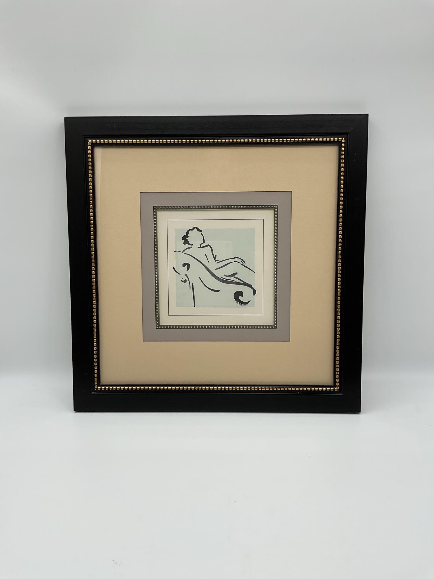 Reclining Silhouette in Chair: Minimalist figure study of a reclining woman drawn in fluid black lines against a pale blue background. Elegantly matted and framed in black with metallic bead detail.Dimensions : H22in