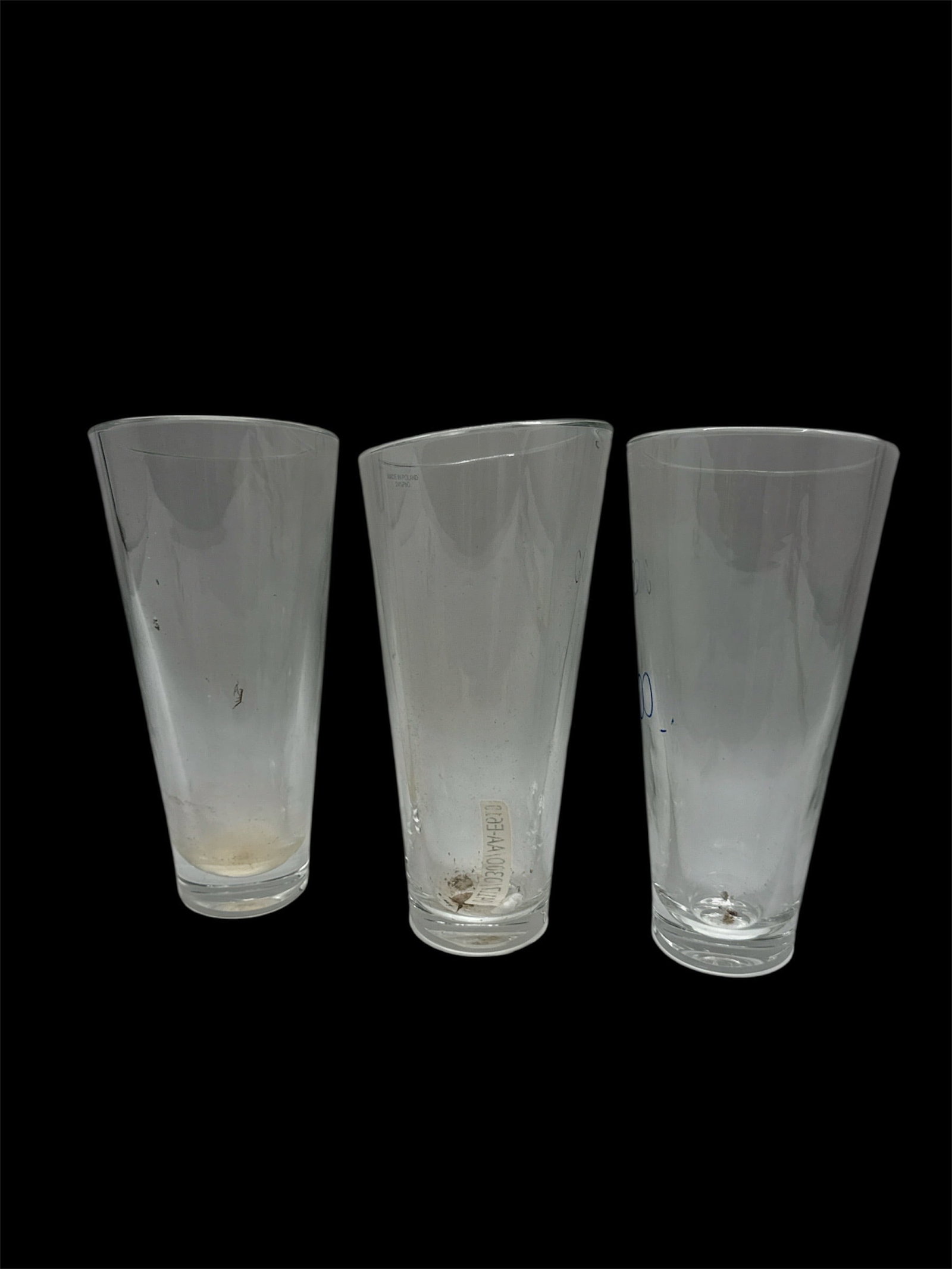 Set of Three Clear Glass Tall Tumblers: A set of three clear glass tall tumblers featuring a simple tapered cylindrical form with thick bases. The clean, minimalist design makes these glasses versatile for use as beverage tumblers, water gl