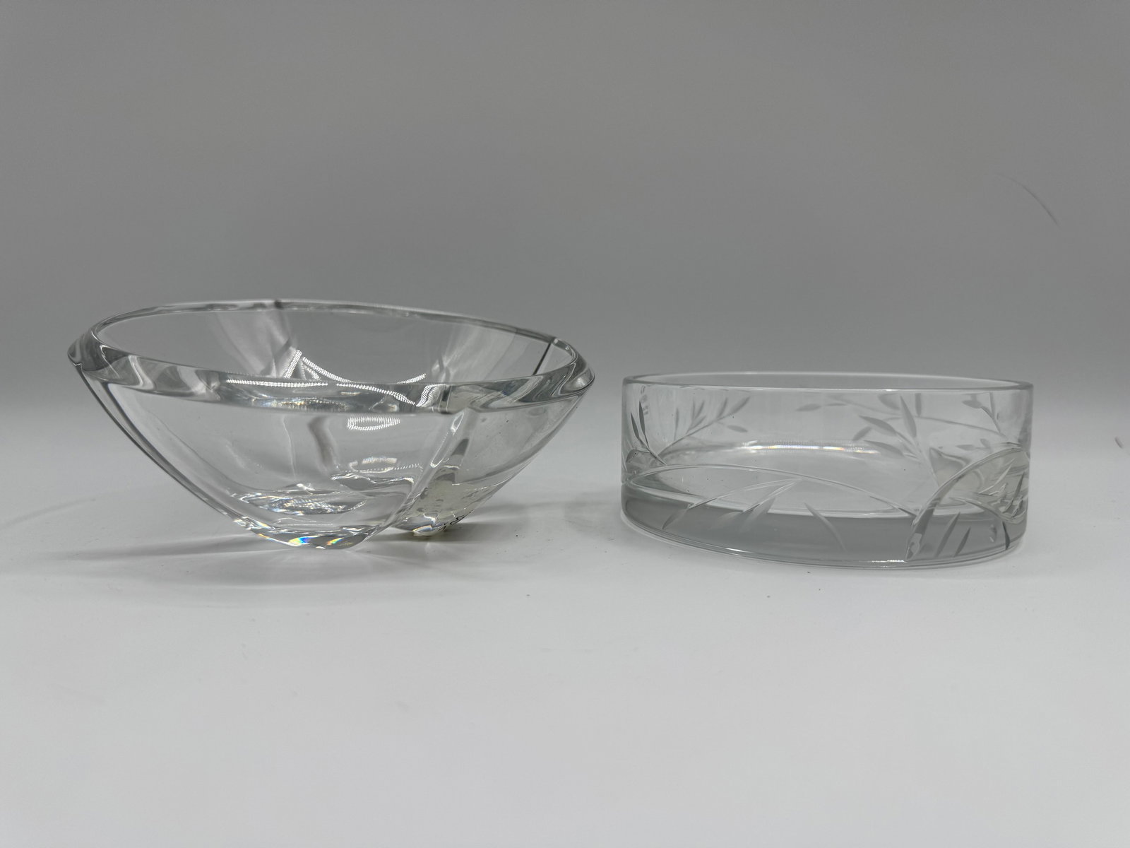 Two Etched Glass Bowls: Two clear glass bowls, one with a geometric design and the other with an etched floral pattern. Both are suitable for serving or display.