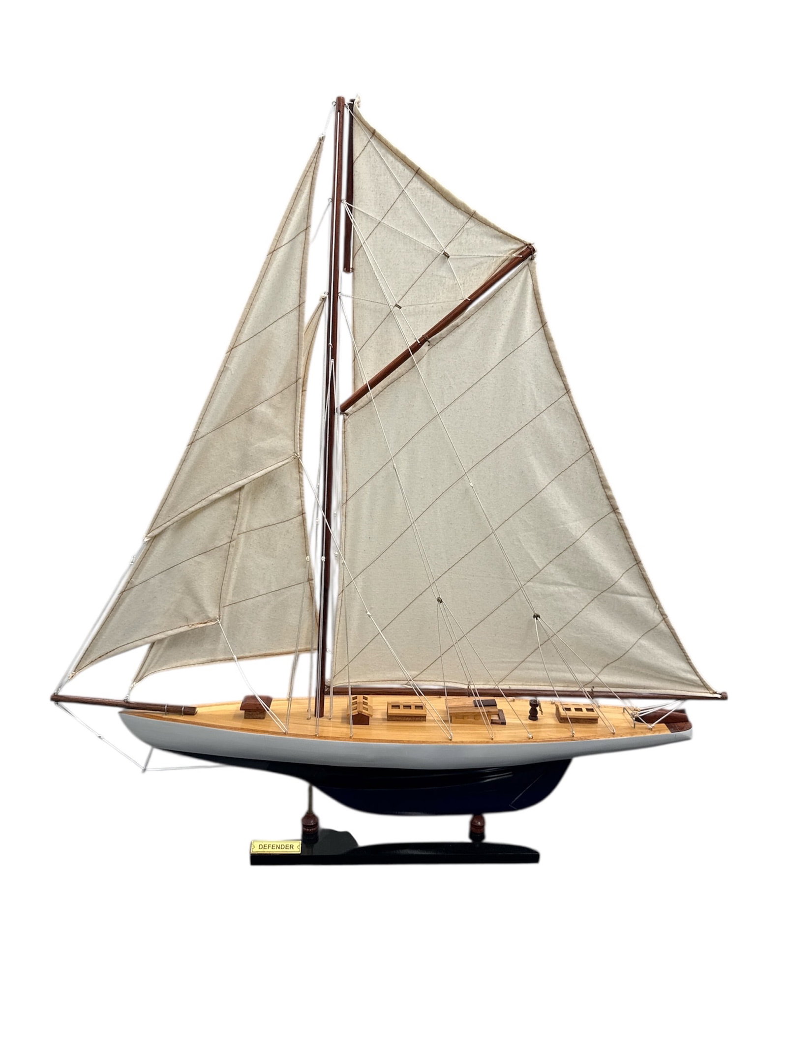 Decorative Model Sailboat with Rigging: Decorative model sailboat featuring a classic hull design mounted on a display base and fitted with fabric sails and detailed rigging. The model showcases traditional maritime craftsmanship with atten