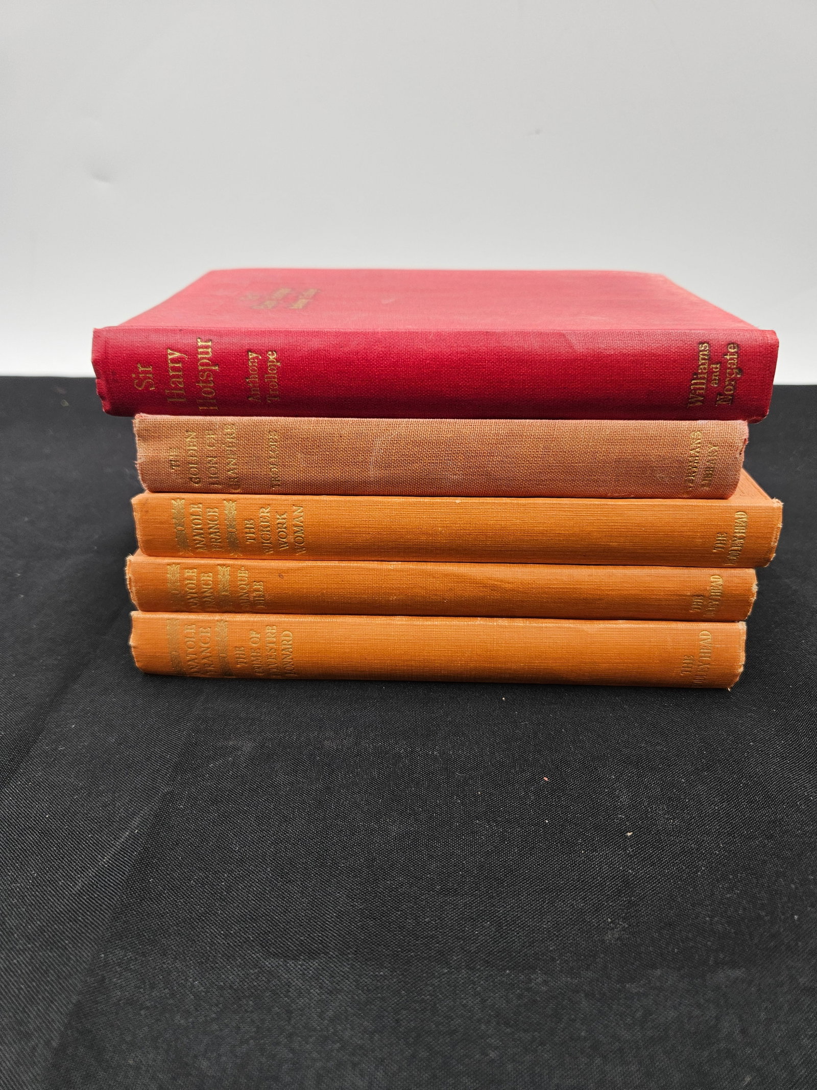 Set of Vintage Grolier Classics Hardcover Books: Collection of five vintage hardcover books published by Grolier, featuring classic literary works. Uniform bindings in red and orange cloth with gilt spine titles. Mid-20th century editions, showing l