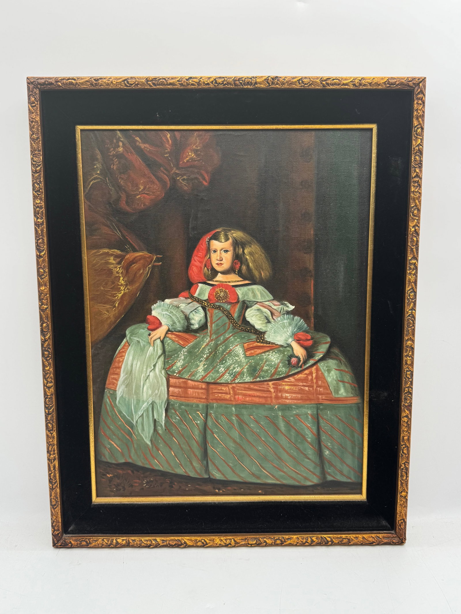 Margarita Teresa after Diego Velaszquez: Description: Framed painting depicting a woman in a green dress and red headscarf. The piece is framed in a black and gold tone frame. Medium: Oil on canvas Dimensions: &nbs