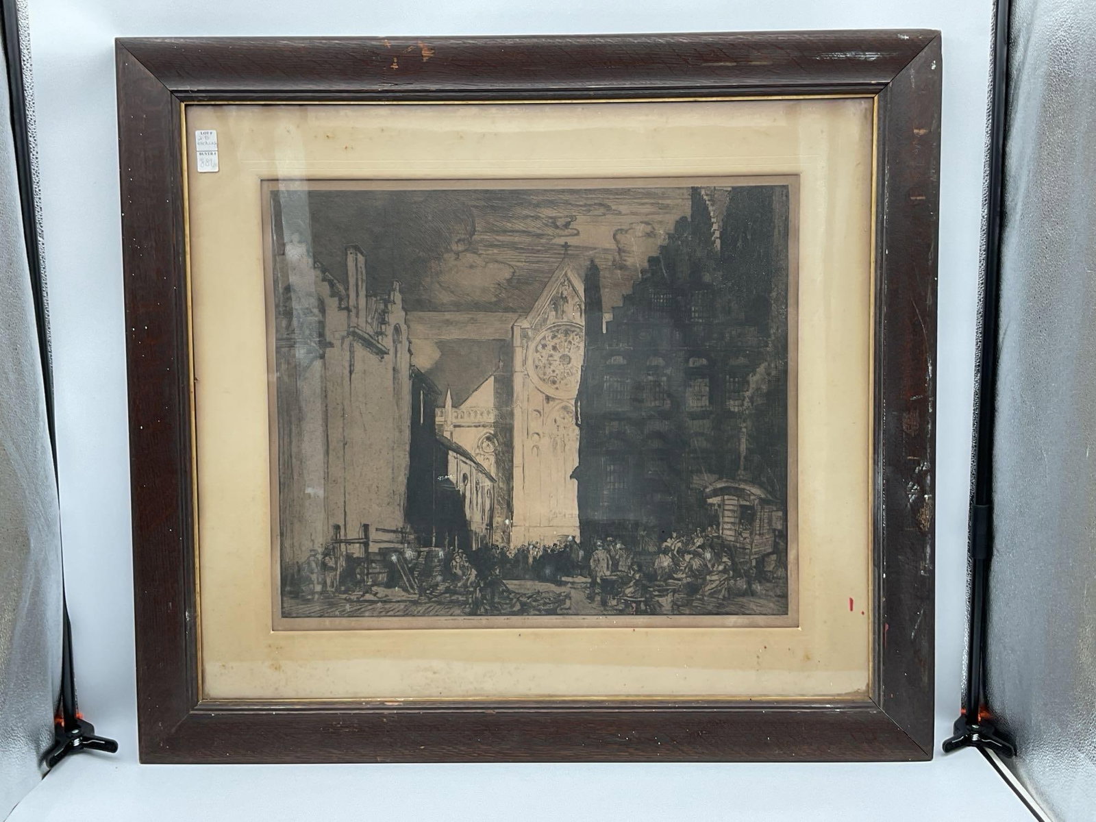 Frank Brangwyn (American/British, 1867-1956) Etching: Atmospheric etching of a Gothic cathedral square, likely French, with prominent rose window and active figures in the foreground. Strong contrasts between light and shadow add depth to the architectur