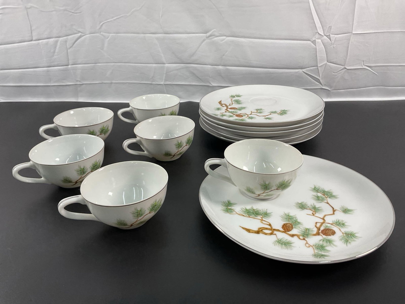 Laurel China "Pine" Pattern 6-Piece Dinnerware Set: This vintage dinnerware set features the "Pine" pattern by Laurel China, Japan. The set includes six cups and matching plates, each adorned with a delicate pine branch and cone design in gre