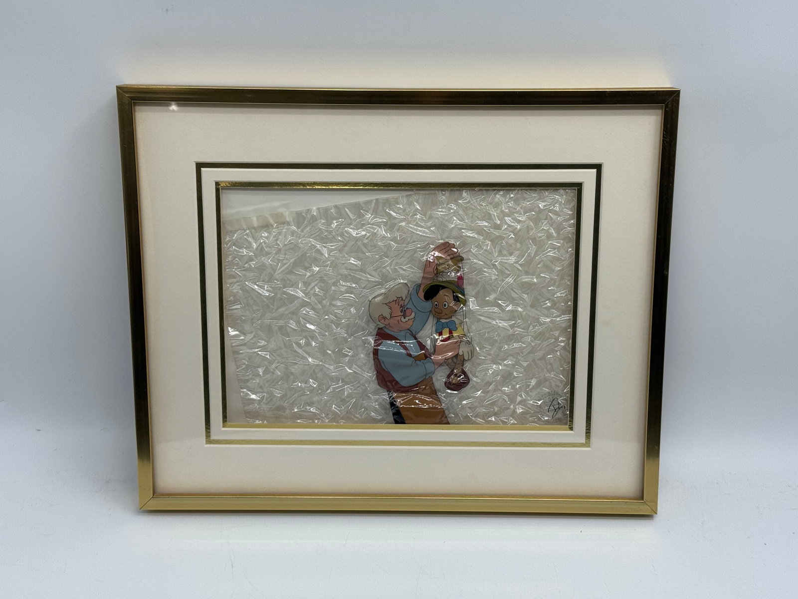 Walt Disney's Pinocchio Serigraph Cel: Description: Original hand painted moving Sericel from Walt Disney company. Depicting Pinocchio and Gepetto. Medium: Serigraph cel Dimensions: 21 x 17 inches.