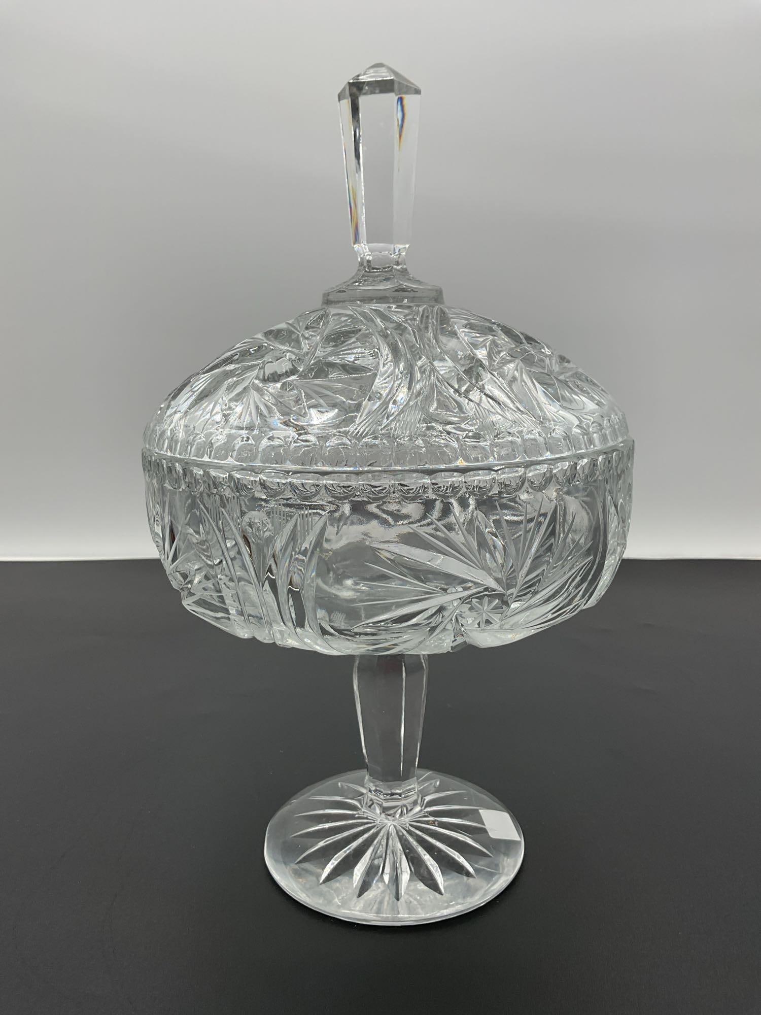Vintage Cut Crystal Pedestal Candy Dish with Lid - Royal Shell Collection:  This is a vintage cut crystal candy dish featuring intricate cut designs, including starburst and leaf patterns. The dish sits on a pedestal and includes a lid with a faceted finial that adds a