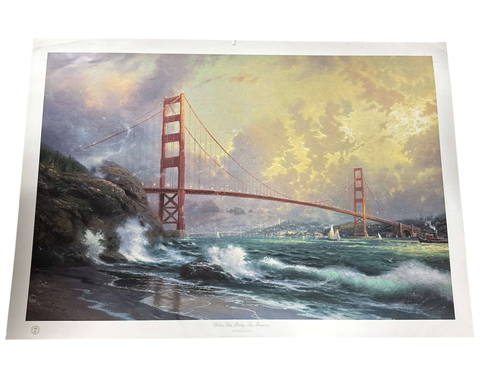"Golden Gate Bridge, San Francisco" by Thomas Kinkade (United States, 1958-2012) Offset lithograph: This scene depicts the iconic Golden Gate Bridge from a coastal perspective, featuring crashing waves in the foreground and sailboats in the bay under a dramatic, light-filled sky. Details Artist: