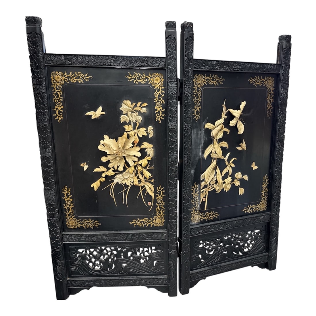 19th Century Chinese Hand Carved Ornate Two Panel Screen: A 19th century Chinese hand carved two panel folding screen featuring ornate relief decoration of birds, butterflies, and flowering branches set against a black lacquer ground. The panels are richly d