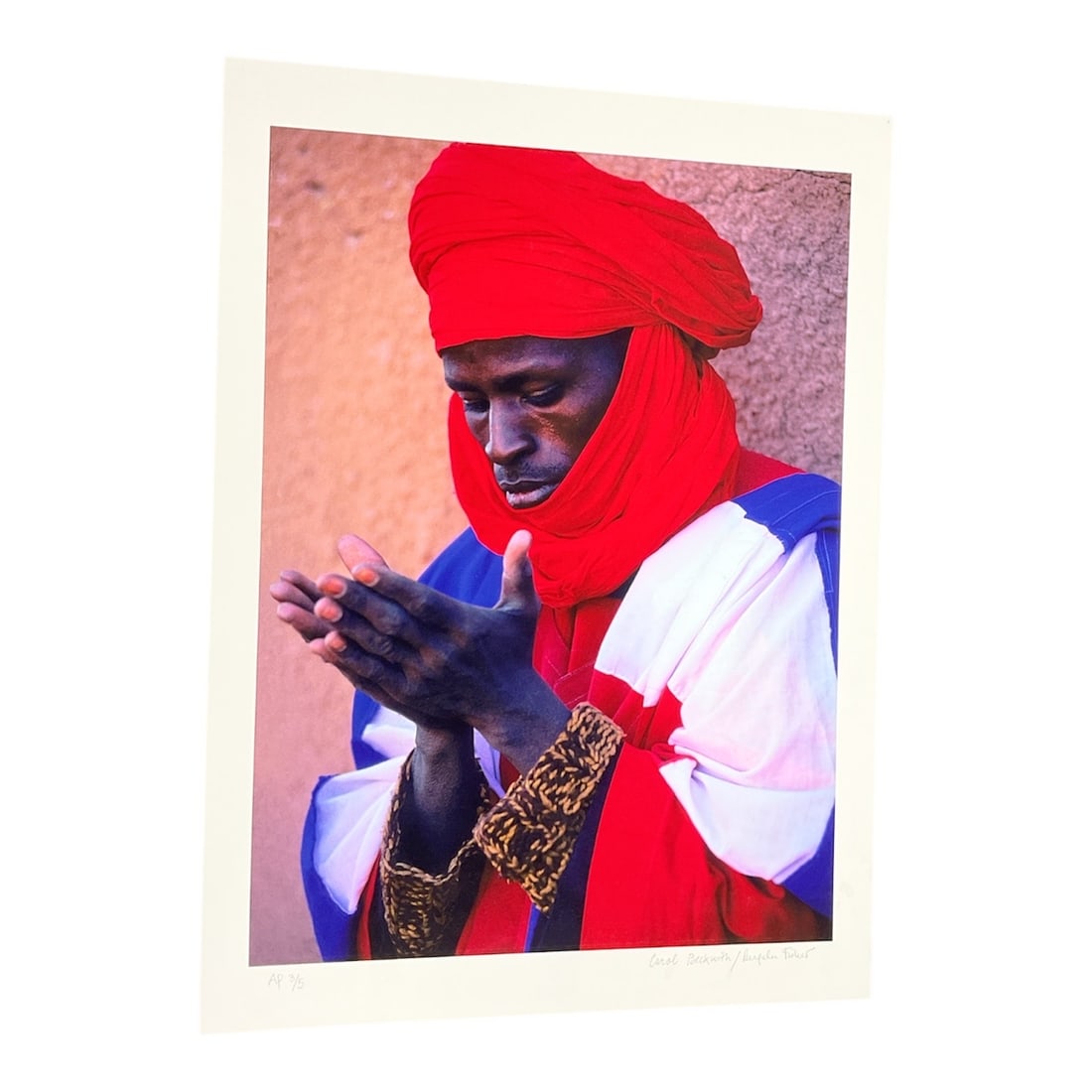 "Dinka Man, South Sudan" by Angela Fisher (Australia, B.1947) and Carol Beckwith (USA, B.1945): This color photograph captures a Dinka man in South Sudan, adorned with traditional beaded necklaces and intricate facial scarring, a practice signifying cultural identity and status. He is depicted i