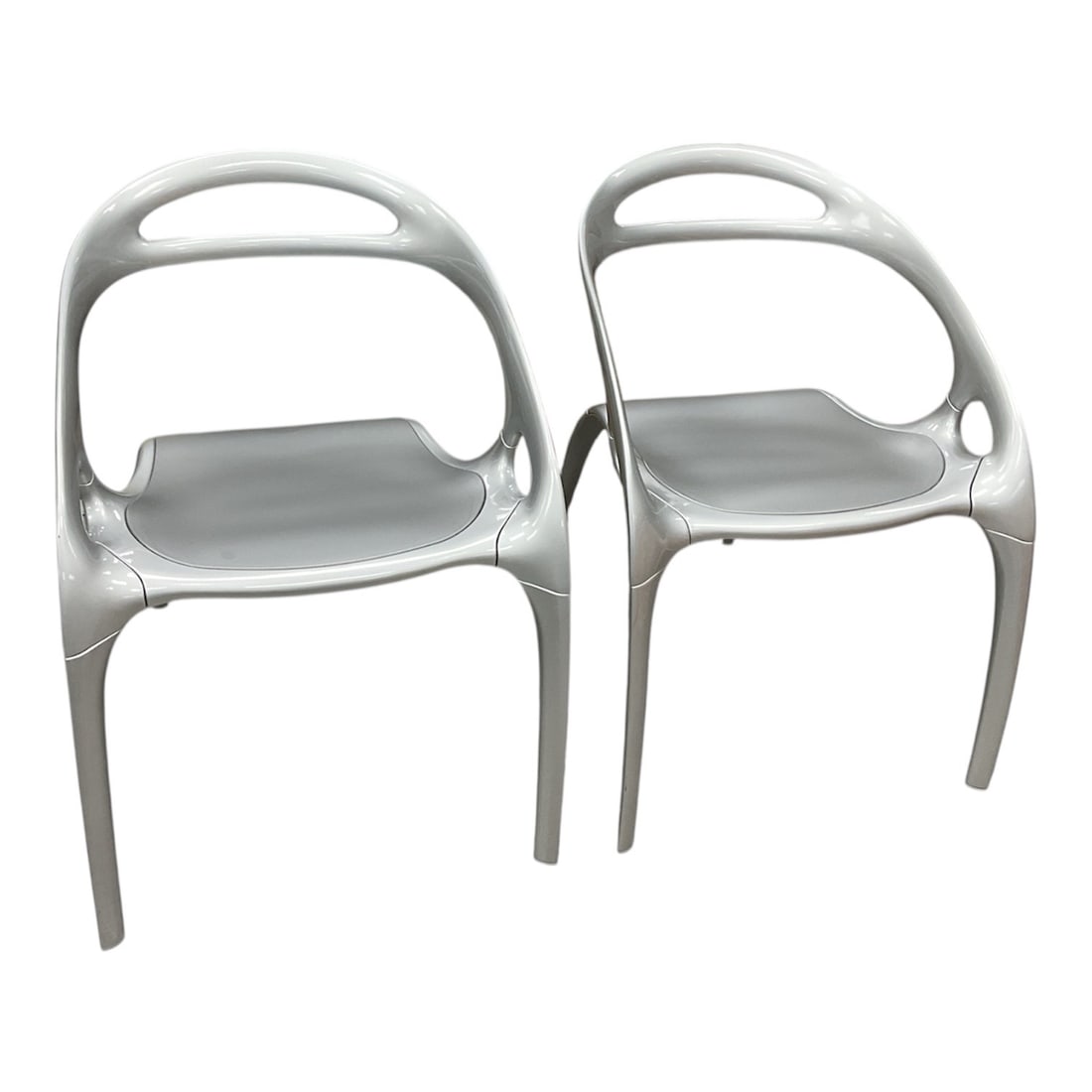 Pair of Go Collection Chairs by Bernhardt Design: Striking pair of Go Collection chairs by Bernhardt Design, featuring a futuristic, sculptural form with smooth, flowing lines and integrated handles. Constructed with a molded frame in a metallic silv