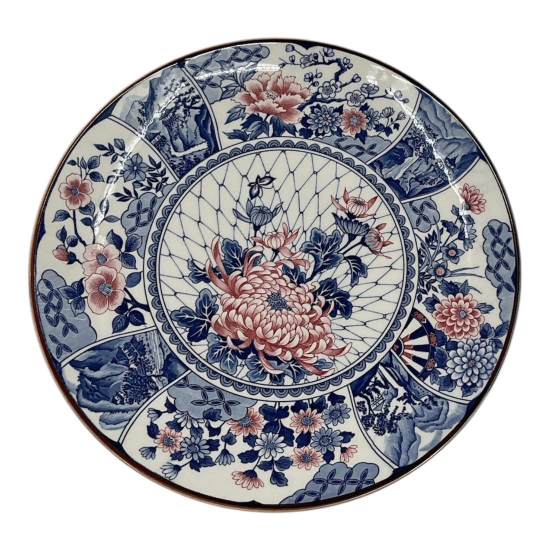 Japanese Imari Style Porcelain Charger: Description:Decorative Japanese porcelain charger featuring a traditional Imari-style design with vibrant blue and red floral motifs. The composition includes a central chrysanthem