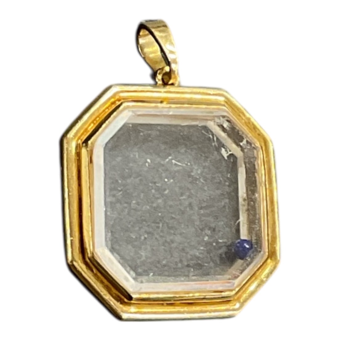 Cartier 18K Yellow Gold Rock Crystal Pendant with Floating Lapis Lazuli Sphere: A Cartier pendant featuring an octagonal faceted crystal set within a gold tone metal frame. The clear crystal is cut with beveled edges and displays natural internal inclusions that create subtle lig
