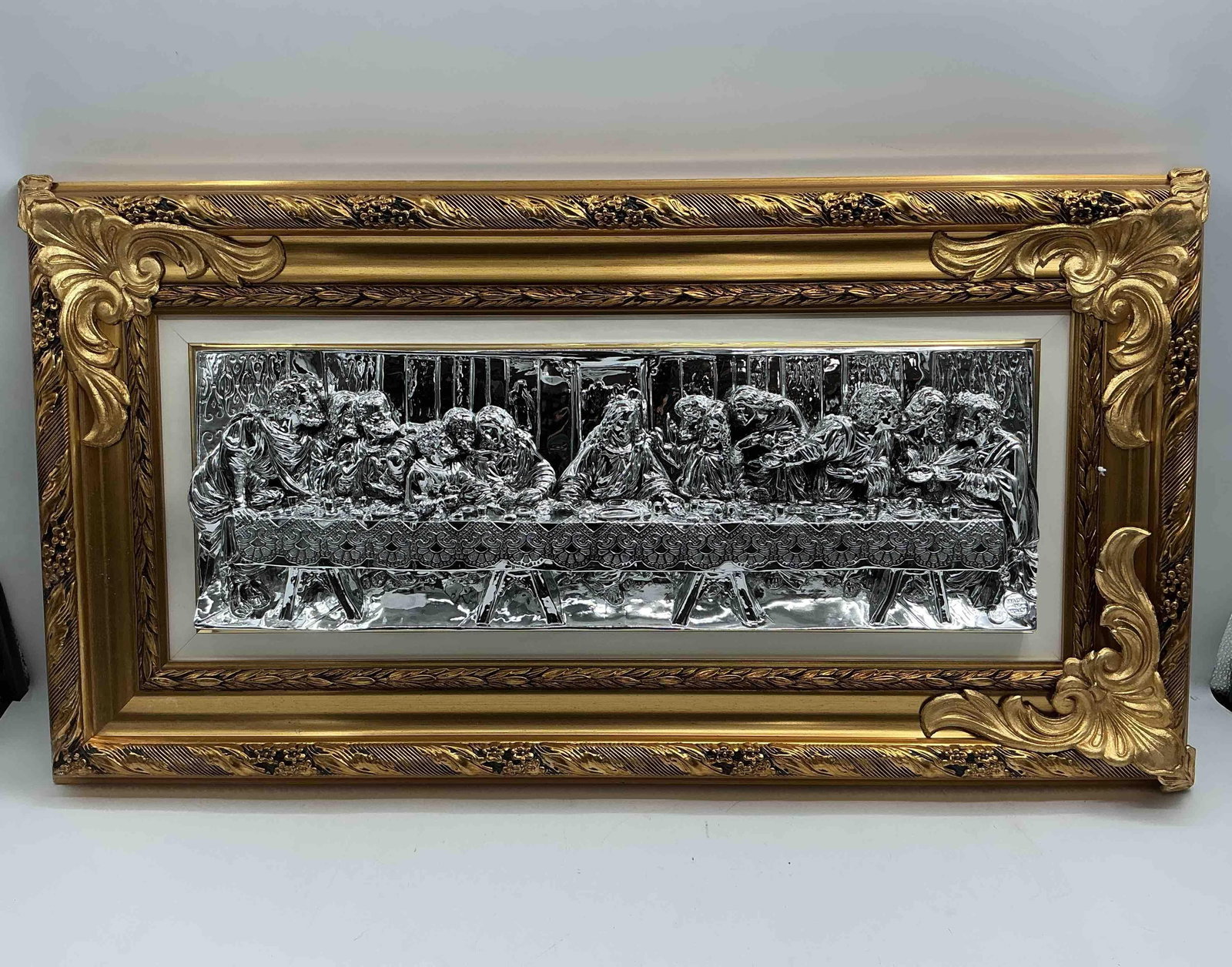 Made in Italy Silver Tone Last Supper Relief Plaque: Detailed silver tone relief depiction of The Last Supper mounted in an ornate gold tone frame marked Made in ItalyMedium Silver tone metal relief in wood and composite frame