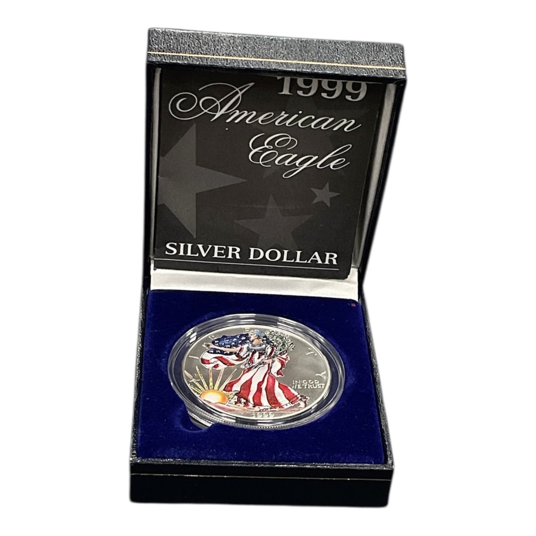 1999 American Eagle Colorized Silver Dollar in Presentation Case: A 1999 American Eagle silver dollar featuring a colorized interpretation of the classic Walking Liberty design. The obverse depicts Lady Liberty draped in the American flag with a rising sun and the i