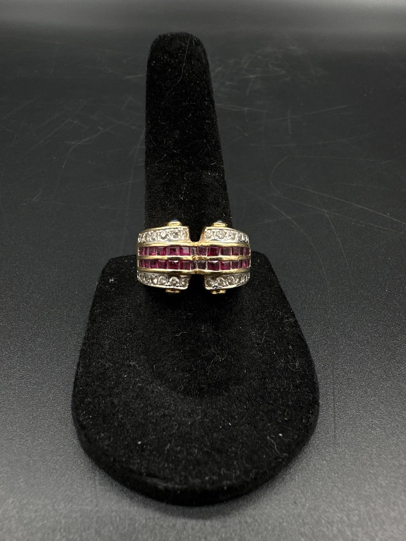 18kt Gold Ruby and Diamond Wrap Ring with Sapphire Accents: Unique 18kt yellow gold wrap-style ring featuring .65ct of square-cut rubies, .50ct of round diamonds, and 4 small sapphire eyes at the ends. Weighs 9.25 grams. Size 6.5.Medium: 18kt gold, rubies, dia