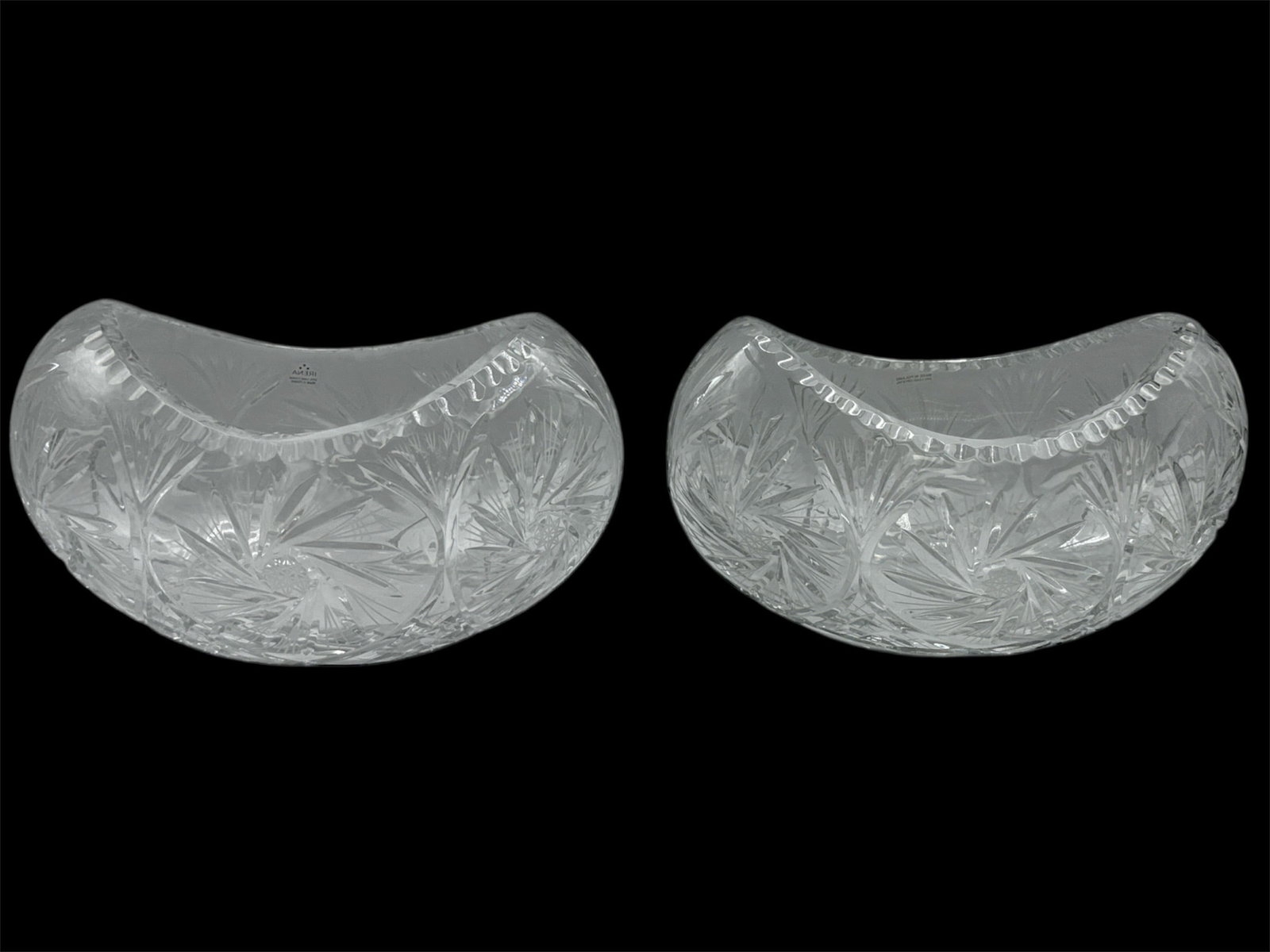 Pair of Cut Crystal Crescent Form Centerpiece Bowls: Striking pair of heavy cut crystal bowls in an elegant crescent or banana form. Each piece features deeply cut starburst and geometric patterns across the body, creating brilliant light refraction and